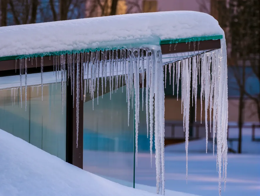 Наледь и сосульки по краю стеклянного навеса
