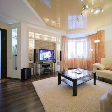 Натяжной потолок с подвесными светильниками и треками в кухне