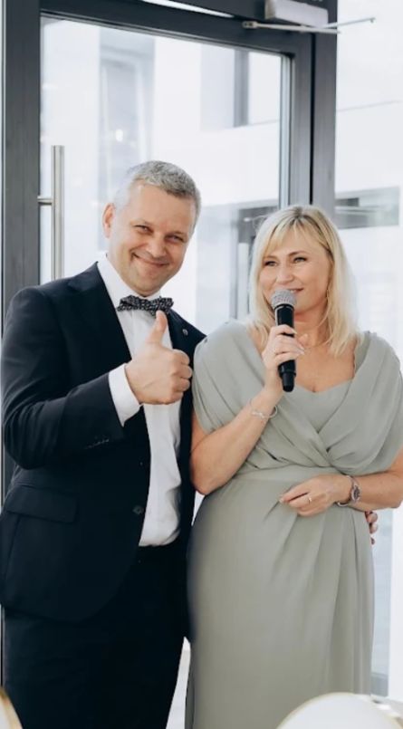 Мужчина и женщина стоят вместе. Женщина с микрофоном поёт песню