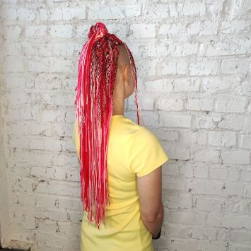 Профиль девушки с зи-зи-косичками в ярко-красных оттенках и выбритым виском