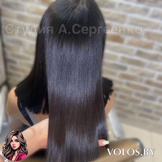 Женщина с идеально ровными и сияющими волосами после комплекса процедур по восстановлению